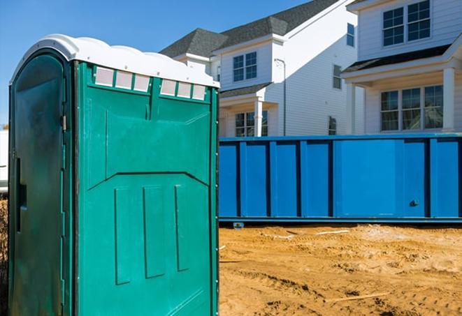 a row of blue and white portable toilets on a busy job site